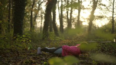 woman doing push-ups in a sunlit forest