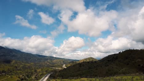 Aerial,-Picturesque-highway-winding-through-California-foothills-on-cloudy-day