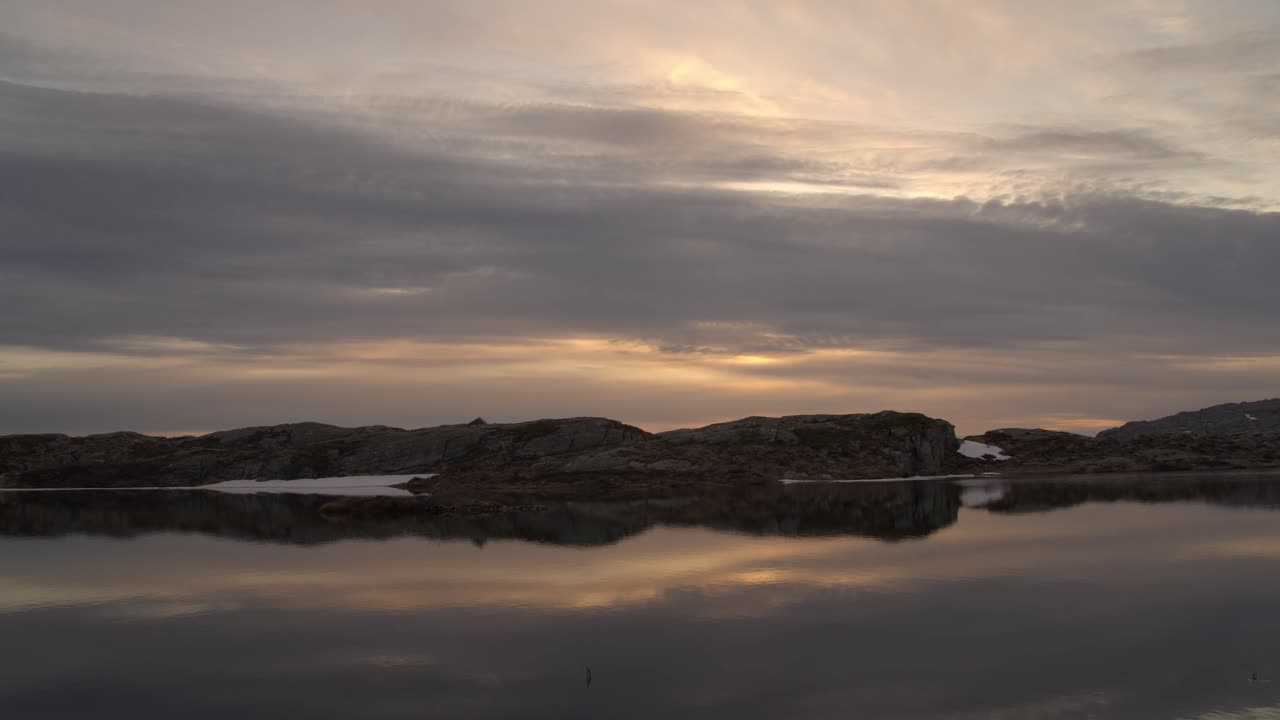 lapso de tiempo al atardecer con reflejos en el lago de montaña y la silueta de la tienda