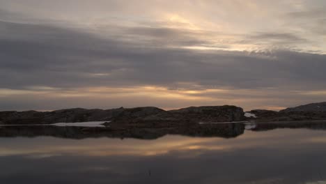 sunset timelapse with reflections in mountain lake and silhouette of tent
