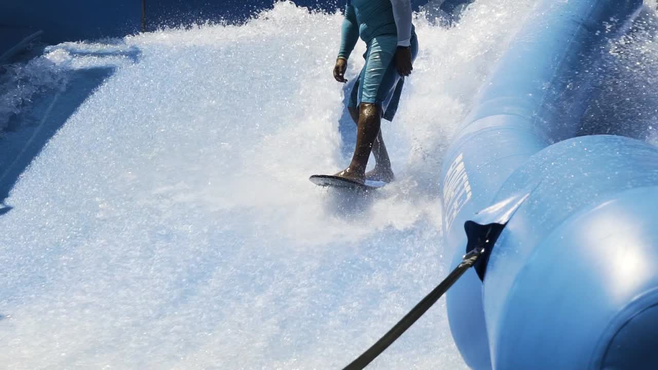 숙련된 라이더가 파도 기계에 뛰어들어 서핑을 합니다.