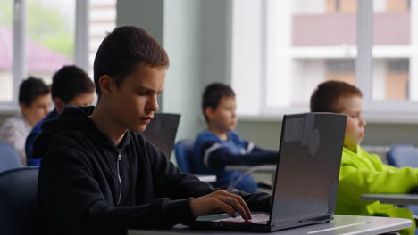 students working on laptops in class