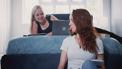 dos estudiantes universitarias en una habitación de casa compartida estudiando juntas