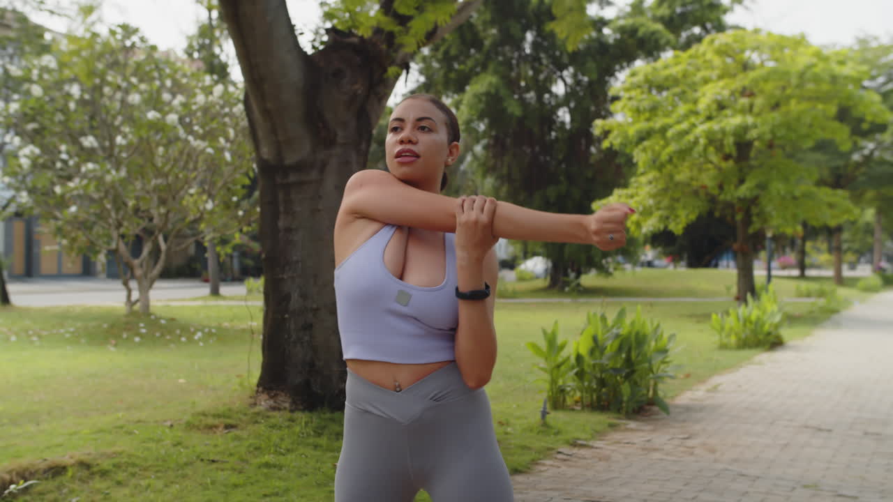 Young Hispanic Woman Warming up in City Park