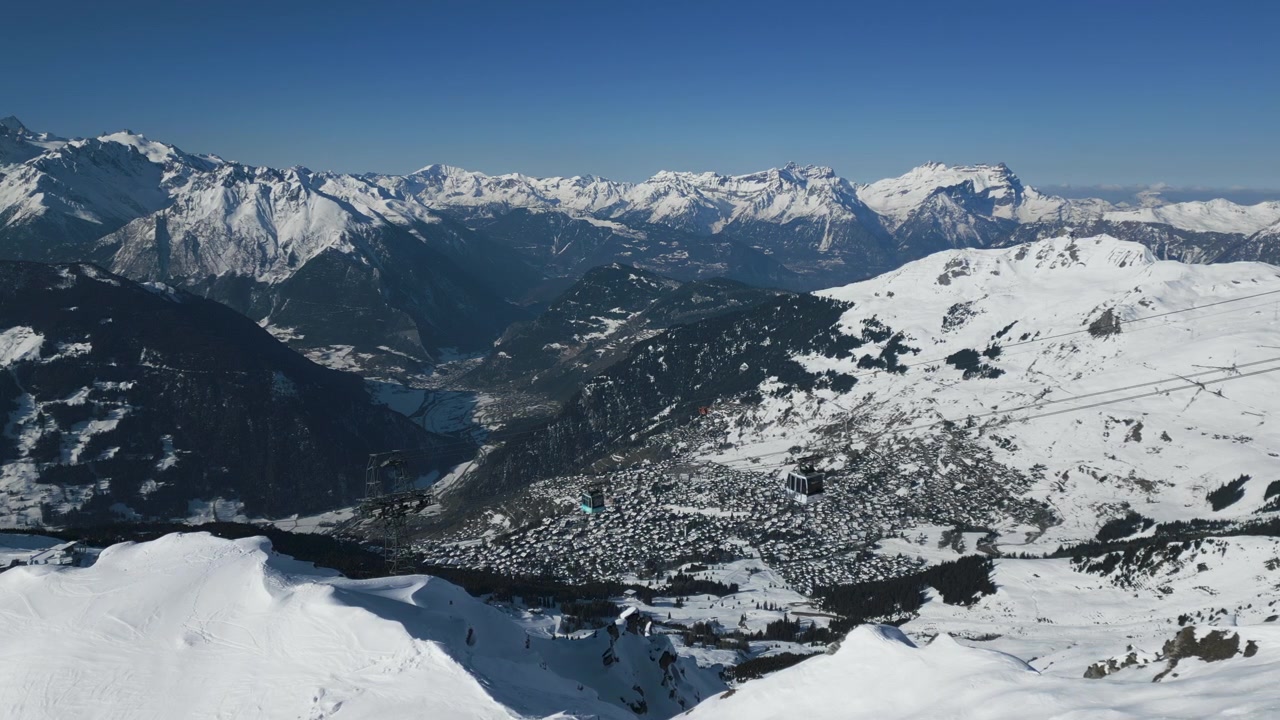 Vista aerea di alcune gondole che salgono in cima alle piste da sci a Verbier, Svizzera