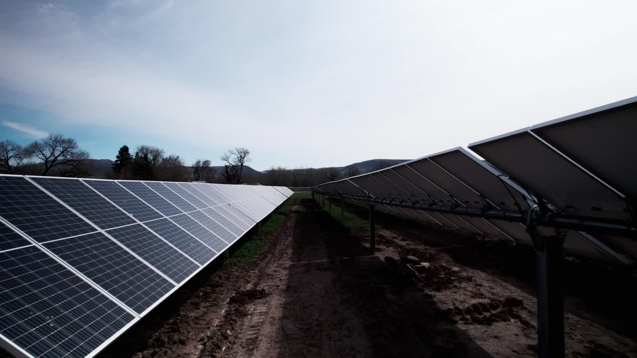 volando entre filas de paneles eléctricos solares en una instalación de producción de energía verde, antena