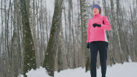 una joven que corría por la mañana en el bosque invernal estaba cansada y se detuvo para recuperar el aliento. recuperó sus fuerzas, superó la fatiga y continuó corriendo. perseverancia y superación de las debilidades. empujar hacia adelante