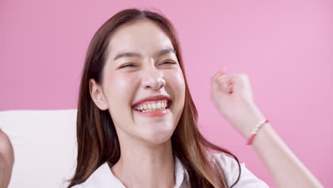 카메라를 보고 성공을 축하하는 아름다운 아시아 여성