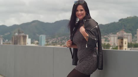 on a rooftop overlooking the city of port of spain, trinidad, a woman enjoys the moment with buildings in view
