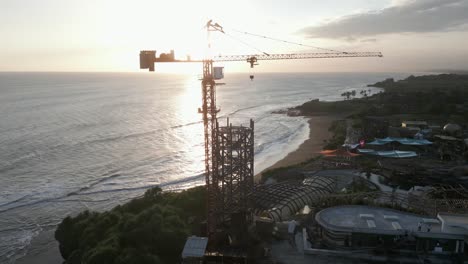 la antena del océano al atardecer gira alrededor de la grúa de la torre en el sitio de construcción