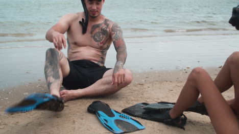 couple putting diving fins on