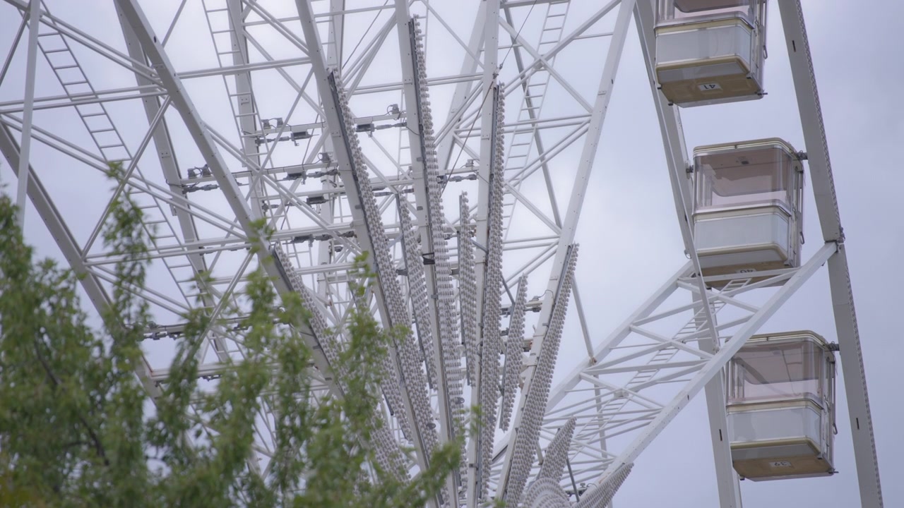 Ferris wheel slowly rotating in a park