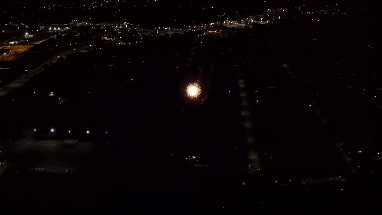 Aerial shot of fireworks with city lights in the background.  City Night Lights.  4K footage.