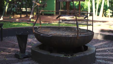 large outdoor grill situated in a lush green park with trees in the background