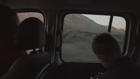 child capturing nature scenes during road trip in the mountains