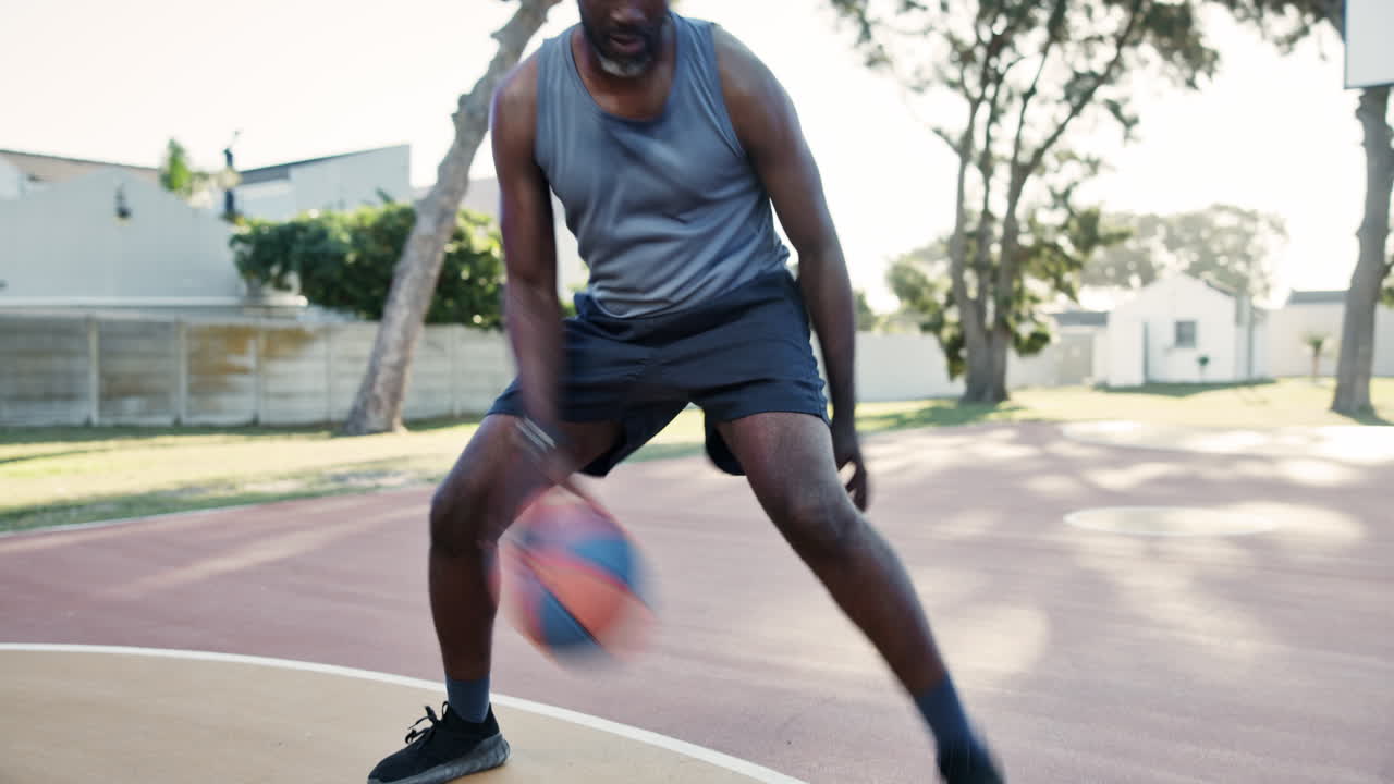 Man dribbling a basketball on an outdoor court
