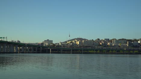 agua que fluye del río han en seúl, corea del sur con la carretera junto al río y la torre namsan de seúl en segundo plano