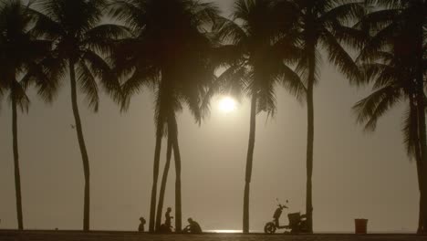 Beautiful-tropical-scenery,-sunlight-illumination,-people-silhouettes