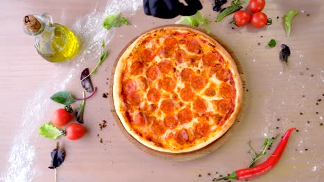 cook puts spinach leaves on pizza salami hands in rubber gloves.