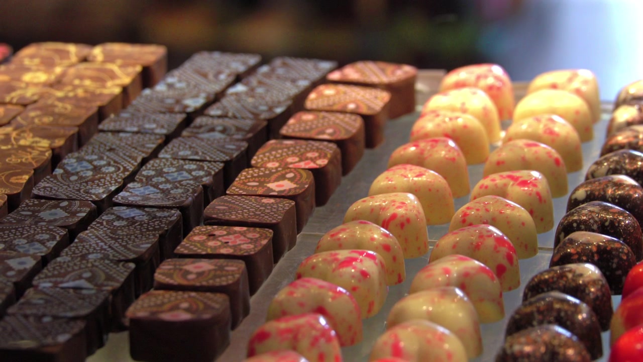チョコレートショップに並べられた手作りチョコレートを流れるように撮影したショット。