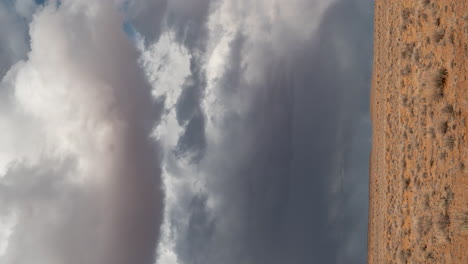 vertical 4k timelapse, stormy clouds above desert landscape, rocks and sand