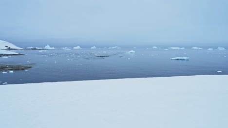 Snowy Winter Landscape with Icebergs in Antarctica, Snow and Iceberg Scenery in Antarctic Peninsula Looking Out to Ocean Sea Water from Mainland Antarctica Land