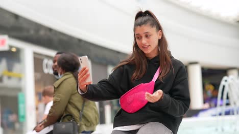 adolescente usando un teléfono inteligente en un centro comercial