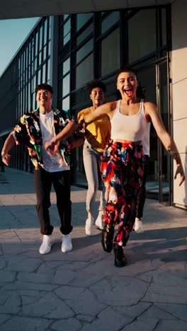 four multi ethnic dancers joyfully leaping in front of a modern urban building, radiating energy and passion for dance, embodying freedom and youthful excitement in the cityscape