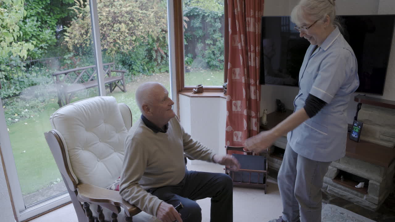 Caregiver assisting elderly man in his home