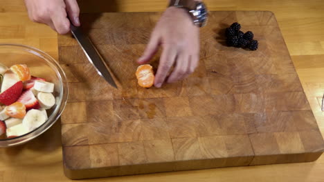 cutting mandarin orange and blackberries for fruit smoothie