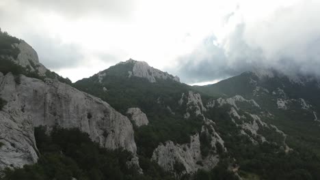 Vuelo-De-Drones-Hacia-Las-Montañas-En-El-Parque-Nacional-Velebit-De-Croacia-En-Una-Mañana-Nublada