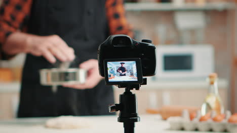 uomo che filma con la telecamera in cucina