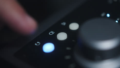 close-up of a person using an audio interface control panel
