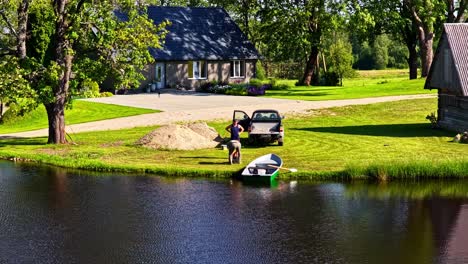 time lapse of two men prepping rowboat by lake shore next to pickup truck