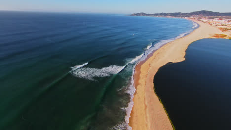 high above the sea waves splashing on the sand in isla san jose on the gulf of california, baja california, mexico. flyover view from fpv drone