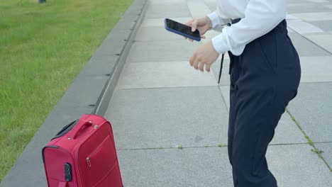 mujer sacando su teléfono de su maleta, primer plano de mano