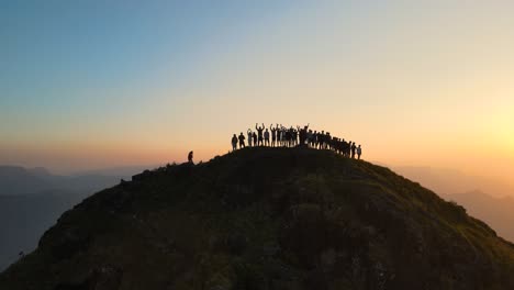 aerial drone shot of kolukkumalai range at sunrise with misty hills and sunlight dancing on the peaks