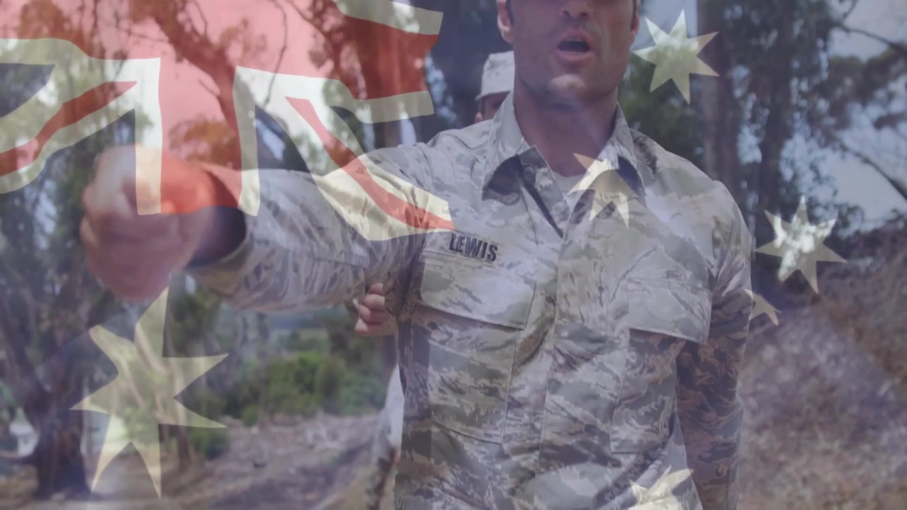 Soldati che marciano su un sentiero nel bosco, con equipaggiamento mimetico e una sovrapposizione trasparente della bandiera australiana per la difesa
