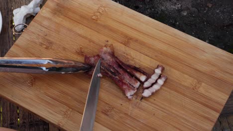 4k hd cinematic top view of a scene featuring streaky pork belly being cut on a wooden board next to a barbecue grill