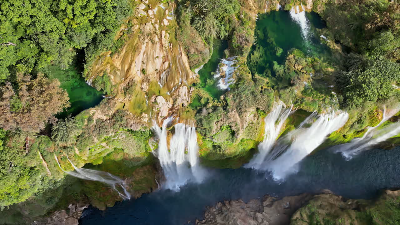 Vista aerea da drone della cascata di Tamul che scende a cascata da scogliere verdi in una piscina turchese sottostante