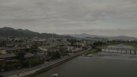 Aerial-Drone-Shot-of-Kyoto-at-Sunset-near-a-river,-Japan,-Asia