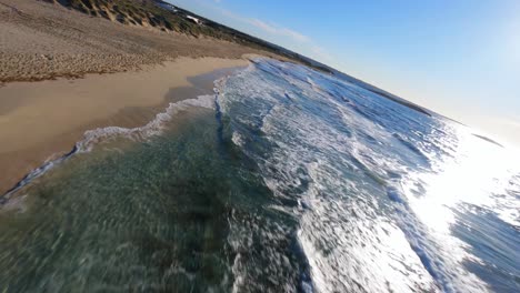 vista aérea de drones fpv volando a lo largo de una pintoresca playa mediterránea a lo largo de la costa de ibiza
