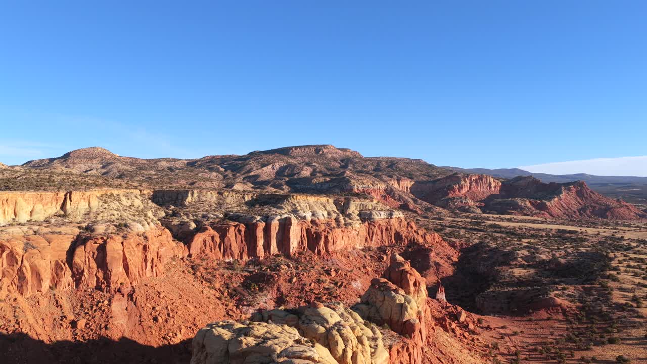 Ripresa con drone segue una cresta di arenaria affilata, salendo e avanzando per rivelare l'immensa natura selvaggia del deserto di Abiquiu. Questa transizione cinematografica cattura la geologia aspra del Sud-ovest
