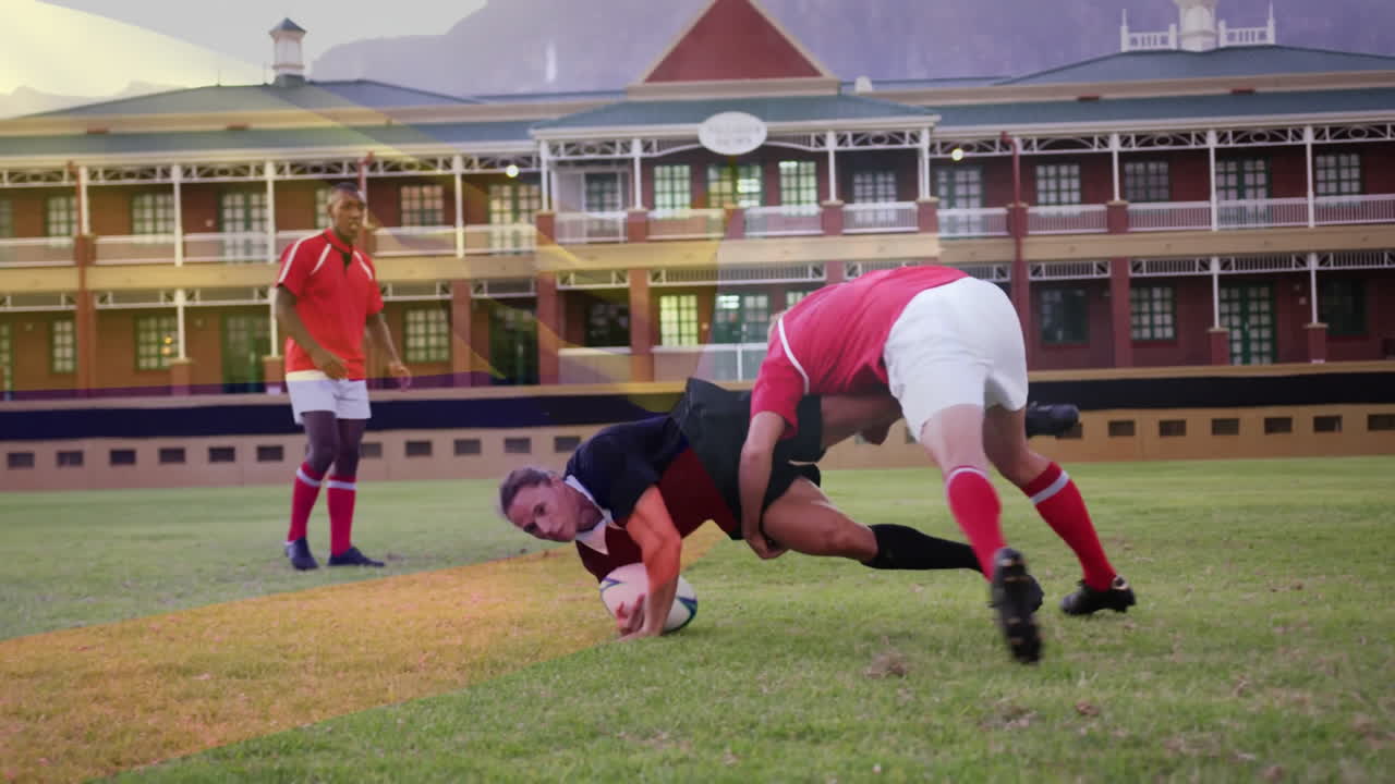 Tackling on field, rugby players with school building visible in background