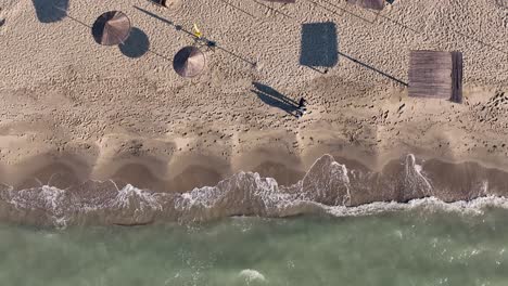 Couple-walking-together-on-a-sandy-beach-near-the-shore