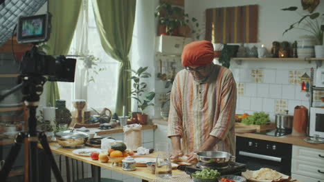 senior food blogger recording cooking tutorial of indian flatbread in kitchen