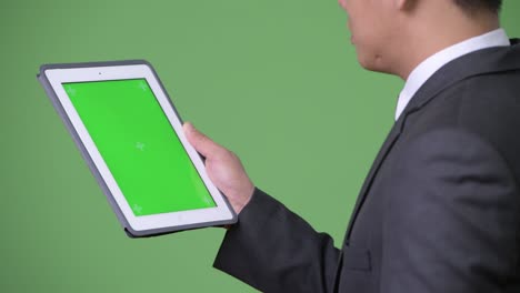 joven empresario asiático guapo usando una tableta digital