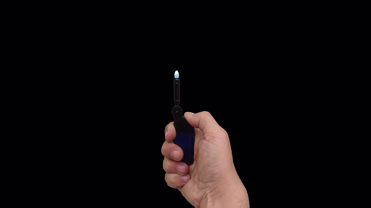 Mano che tiene e accende un accendino tascabile blu.