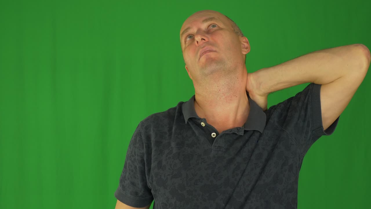 hombre frotando los hombros con la mano izquierda. vista delantera de la cintura en camisa polo.