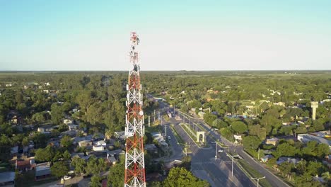 aerial view of sunny morning above suburbia, communication and tv tower and road